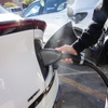 A man unplugs his electric vehicle after fully charging at the Electrify America charging station in the Southern Premium Outlets parking lot, Tuesday Nov. 21, 2023.