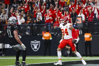 Kansas City Chiefs wide receiver Justin Watson (84) reacts after he scores a touchdown as Las Vegas Raiders linebacker Robert Spillane (41) watches during the first half of an NFL football game at Allegiant Stadium Sunday, Nov. 26, 2023.