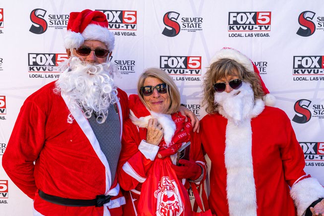 Chuck Ogier, left, Nancy Ogier, center, and Chris Daleiden enjoy the pre-show festivities at the Las Vegas Great Santa Run on Saturday, Dec. 2, 2023.