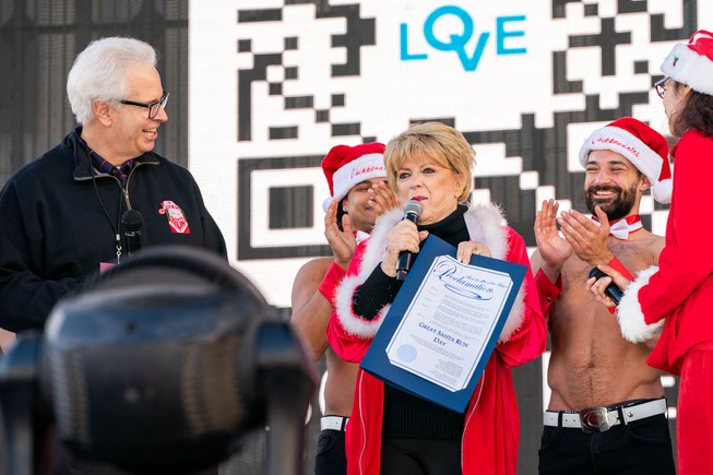 Bob Brown, CEO of Opportunity Village, left, and Mayor Carolyn Goodman present the proclamation for the Great Santa Run Day at the Las Vegas Events Center, on Saturday, Dec. 2, 2023.