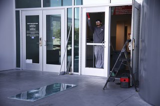 Gesrrel Basulto prepares to board up a damaged window at the UNLV student union building Thursday, Dec. 7, 2023.