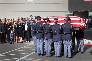 Nevada State Police troopers take the casket of Nevada State Police Sgt. Michael Abbate off a truck as family members, left, look on at Central Church Monday, Dec. 11, 2023, in Henderson. Abbate and Trooper Alberto Felix were killed by a hit-and-run driver on Interstate-15 on Nov. 30.