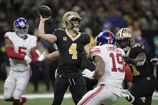 New Orleans Saints quarterback Derek Carr (4) throws under pressure from New York Giants safety Isaiah Simmons (19) during the first half of an NFL football game Sunday, Dec. 17, 2023, in New Orleans. 

