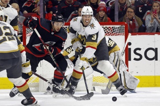 Vegas Golden Knights' Brayden McNabb (3) clears the puck as he tangles with Carolina Hurricanes' Michael Bunting (58) during the first period in Raleigh, N.C., Tuesday, Dec. 19, 2023.



