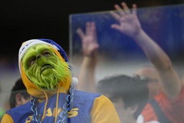 A fan dressed for Christmas watches during the first half of an NFL football game between the Los Angeles Rams and the Denver Broncos on Sunday, Dec. 25, 2022, in Inglewood, Calif.