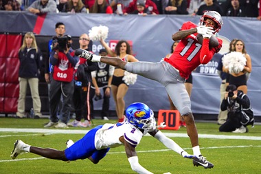 UNLV wide receiver Ricky White makes a reception over Kansas cornerback Cobee Bryant (2) during the second half of the Guaranteed Rate Bowl NCAA college football game Tuesday, Dec. 26, 2023, in Phoenix. Kansas won 49-36.