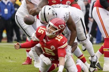 Kansas City Chiefs quarterback Patrick Mahomes (15) fumbles as he is hit by Las Vegas Raiders defensive end Malcolm Koonce (51) during the first half of an NFL football game Monday, Dec. 25, 2023, in Kansas City, Mo.