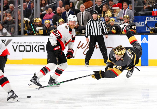 Vegas Golden Knights center Brett Howden (21) falls in front of Ottawa Senators right wing Claude Giroux (28) while chasing after the puck in the third period of an NHL hockey game Sunday, Dec. 17, 2023, in Las Vegas. (AP Photo/)