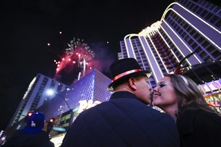 Luke Browning, left, and Brittany Browning of Kentucky share a moment as fireworks explode over the Plaza in Downtown Las Vegas on New Years Eve Monday Jan. 1, 2024.
