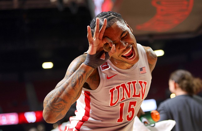 UNLV Rebels guard Luis Rodriguez (15) celebrates by the bench after a three-point basket by UNLV during the first half of a NCAA basketball game against the Utah State Aggies at the Thomas & Mack Center Saturday, Jan. 13, 2024.