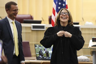 Barbara F. Schifalacqua buttons up a robe as she is sworn in as Henderson Justice Court, Justice of the Peace, Department III during an investiture ceremony at Henderson City Hall Thursday, Jan. 18, 2024. Schifalacquas husband Marc stands on the left.