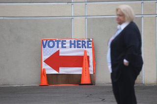An election worker waits for people to vote in Nevada's presidential preference primary at the Desert Breeze Community Center polling site Tuesday, Feb. 6, 2024.
