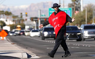 Clark County School District Police officer Keith Habig reacts after a car fails to stop for him as he is crossing Russell Road during a Valentines in a Crosswalk pedestrian safety event at Russell and Topaz Street Tuesday, Feb. 13, 2024.