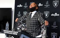 Christian Wilkins, a 6-4, 310-pound defensive tackle, displays a jacket with a playing card design in the liner during a news conference at the Intermountain ...