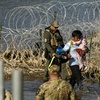Migrants are taken into custody by officials at the Texas-Mexico border, Jan. 3, 2024, in Eagle Pass, Texas. 