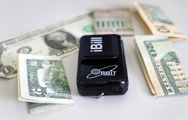 An iBill currency reader is displayed at a Nevada Department of Employment, Training and Rehabilitation (DETR) office on West Charleston Boulevard Friday, March 22, 2024. The device reads aloud the denomination of a bill so that blind people can identify them.