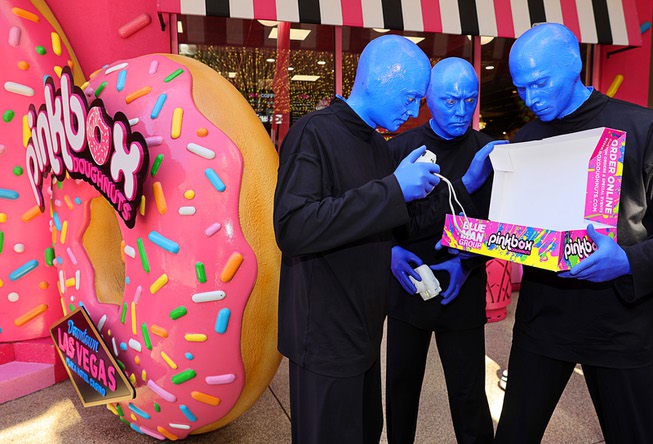 Members of Blue Man Group look over doughnuts during a promotional kick-off for Blue Man Group-inspired doughnuts at The Plaza in downtown Las Vegas Friday, April 12, 2024. The limited-edition doughnuts are called Blue Poo and Throwdown.