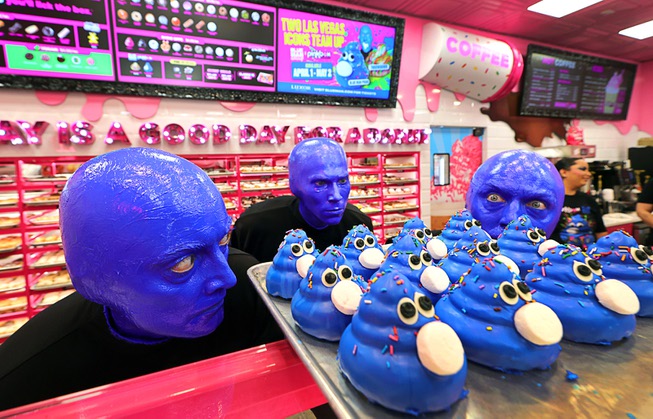 Members of Blue Man Group look over Blue Man Group-inspired doughnuts at The Plaza in downtown Las Vegas Friday, April 12, 2024. The limited-edition doughnuts are called Blue Poo and Throwdown.