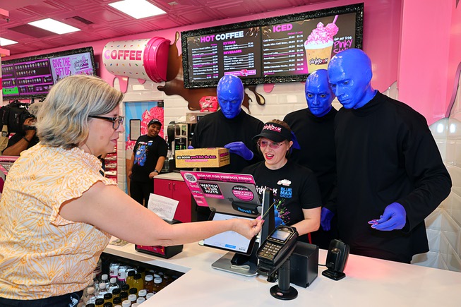 Members of Blue Man Group help out behind the counter during a promotional kick-off for Blue Man Group-inspired doughnuts at The Plaza in downtown Las Vegas Friday, April 12, 2024. The limited-edition doughnuts are called Blue Poo and Throwdown.
