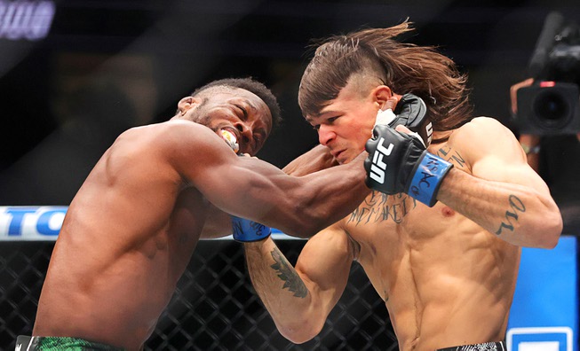 Diego Lopes, right, connects with a punch that knocks down Sodiq Yusuff in the first round of a featherweight bout during UFC 300 at T-Mobile Arena Saturday, April 13, 2024, in Las Vegas. Lopes won the bout with a first-round TKO. 