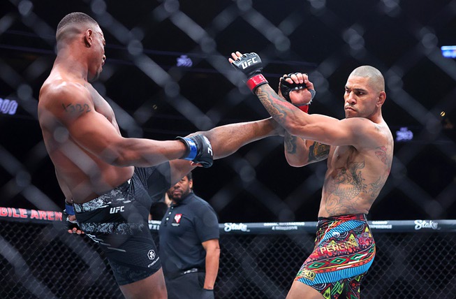 UFC light heavyweight champion Alex Pereira blocks a kick from Jamahal Hill during UFC 300 at T-Mobile Arena Saturday, April 13, 2024, in Las Vegas.