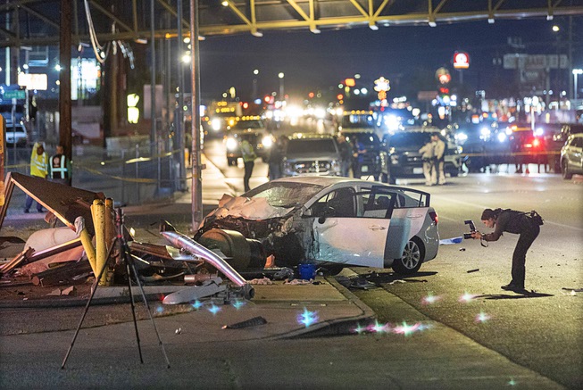 A Metro Police crime scene analyst takes photos of a fatal accident scene at a bus stop on southbound Boulder Highway Wednesday, April 17, 2024. An adult and child are dead and three others were injured, police said. 