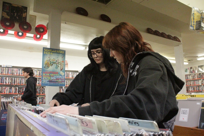 Las Vegas residents Jules Perna and Kylie Schafer look through metal and rock albums at Record City April 20, 2024, on Record Store Day. 