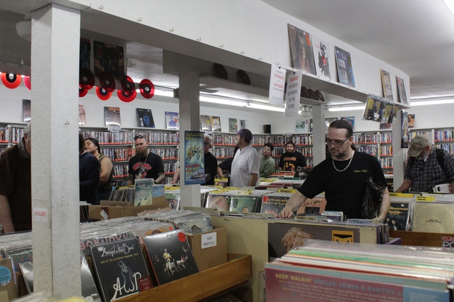 Customers wait in line, as others look through record bins, at Record City on Record Store Day, April 20, 2024.