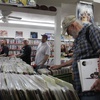Customers wait in line, as others look through record bins, at Record City on Record Store Day, April 20, 2024.