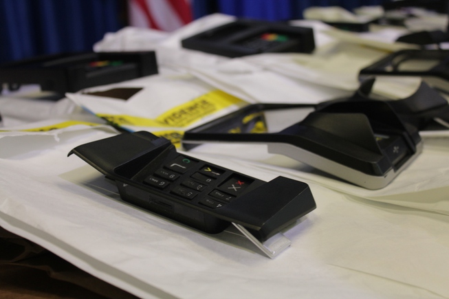 A confiscated skimming device, designed to look like a point-of-sale terminal, sits on a table with other evidence during a Metro Police news conference on April 26, 2024.
