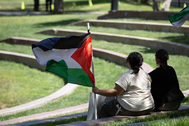 Pro Palestine supporters wave a flag while waiting for other demonstrators on UNLV’s campus, Wed. May 1, 2024.