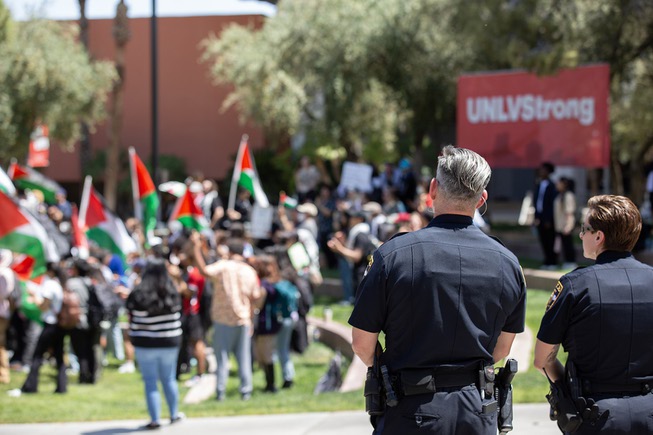 Two UNLV School Police officers look on as pro Palestine supporters demonstrate on UNLV’s campus Wed. May 1, 2024.