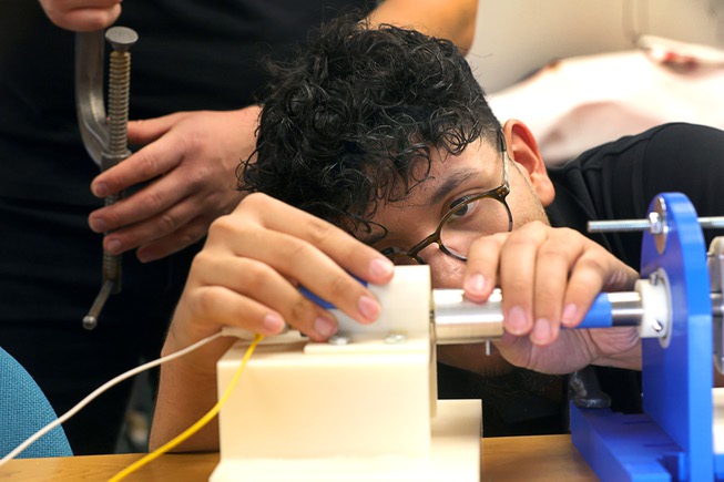 UNLV mechanical engineering student Adrian Rivas helps set up a proof of concept model at UNLV Wednesday, May 8, 2024. The team’s project, “Development of a Magnetic Coupler and Gear Drive,” won the grand prize and sustainability prize at the biannual Senior Design Competition.
