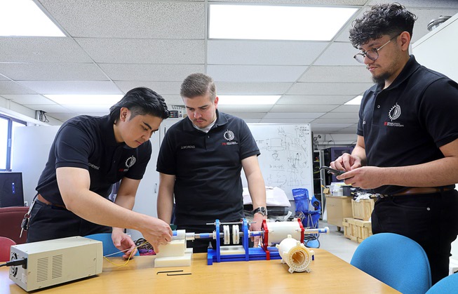UNLV mechanical engineering students, from left, Carlos Miguel Herranz, Gustavo Moreno and Adrian Rivas set up a proof of concept model at UNLV Wednesday, May 8, 2024. The team’s project, “Development of a Magnetic Coupler and Gear Drive,” won the grand prize and sustainability prize at the biannual Senior Design Competition.