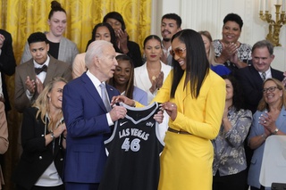 A'ja Wilson, of the WNBA's Las Vegas Aces, right, presents a jersey to President Joe Biden during an event to celebrate the 2023 WNBA championship team, in the East Room of the White House, Thursday, May 9, 2024, in Washington.