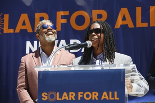 Senator Dallas Harris (D-NV 11th District) speaks during a press conference held to highlight how the Solar for All program is making an impact on disadvantaged Las Vegas communities Tuesday, May 28, 2024. Representative Steven Horsford (D-NV 4th District), left, looks at the sun on a particularly hot, 100-degree day. 