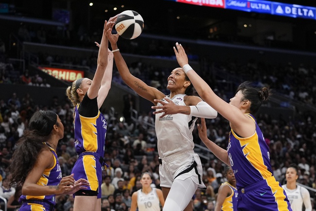 Las Vegas Aces center A'ja Wilson, second from right, shoots against, from left, Los Angeles Sparks guard Lexie Brown, forward Cameron Brink, and center Li Yueru during the first half of a WNBA basketball game, Sunday, June 9, 2024, in Los Angeles.