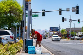 With temperatures in the 100’s during the early afternoon hours, Tuyet “Lisa” Phan, 52, fills a water cooler with ice and water, that is chained to the Route 203 bus stop post where many passengers wait in the unshaded bus stop on Spring Mountain in Las Vegas, Nevada, on Monday, July 1, 2024.