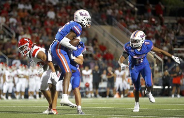 Bishop Gorman defensive back Jett Washington (5) intercepts a pass intended for Kahuku (Hawaii) High School’s Noah Ah You (33) during the second half of a high school football game at Bishop Gorman’s Fertitta Field Friday, Aug. 16, 2024, in Las Vegas. Bishop Gorman linebacker Landon McComber (11) looks on at right.