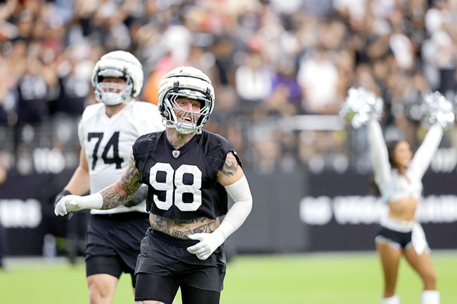 Las Vegas Raiders defensive end Maxx Crosby (98) and offensive tackle Kolton Miller (74) head onto the field during a training camp open practice at Allegiant Stadium Tuesday, Aug. 20, 2024.