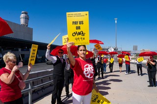 Kim Wells, local Union rep holds up a sign that reads “99.9%” after hearing the final results. United Airlines employees demonstrated nationwide and at Harry Reid International Airport in Las Vegas, Nevada as they announced the results of strike authorization vote on Wednesday, August 28, 2024.