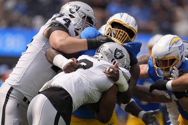 Los Angeles Chargers defensive tackle Otito Ogbonnia, top middle, tackles Las Vegas Raiders running back Zamir White, bottom, as offensive tackle Kolton Miller (74) tries to block during the first half of an NFL football game, Sunday, Sept. 8, 2024, in Inglewood, Calif. 