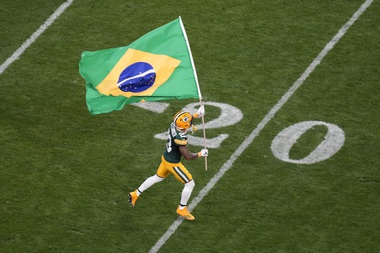 Green Bay Packers cornerback Jaire Alexander (23) runs with the Brazilian flag during the first half of an NFL football game, Friday, Sept. 6, 2024, at the Neo Quimica Arena in Sao Paulo.