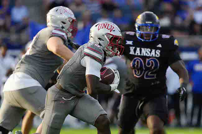 UNLV running back Jai'Den Thomas, center, runs the ball against Kansas in the first half of an NCAA college football game Friday, Sept. 13, 2024, at Children's Mercy Park in Kansas City, Kan. (AP Photo/Ed Zurga)