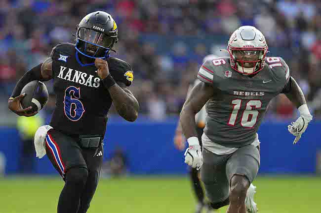 Kansas quarterback Jalon Daniels (6) runs for a touchdown against UNLV linebacker Mani Powell (16) in the first half of an NCAA college football game Friday, Sept. 13, 2024, at Children's Mercy Park in Kansas City, Kan. (AP Photo/Ed Zurga)