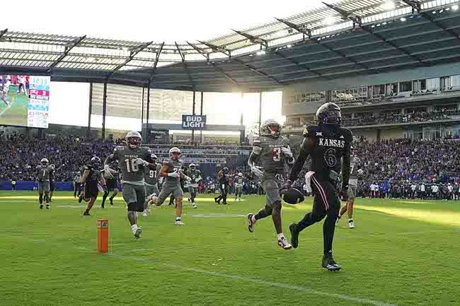 Kansas quarterback Jalon Daniels (6) runs into the end zone past UNLV defensive back Johnathan Baldwin (3) for a touchdown in the first half of an NCAA college football game Friday, Sept. 13, 2024, at Children's Mercy Park in Kansas City, Kan. (AP Photo/Ed Zurga)