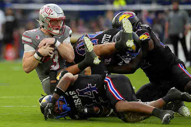 UNLV quarterback Matthew Sluka (3) is sacked by Kansas linebacker Cornell Wheeler (44) and safety Mason Ellis (23) during an NCAA college football game Friday, Sept. 13, 2024, at Children's Mercy Park in Kansas City, Kan. (AP Photo/Ed Zurga)