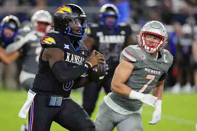 Kansas quarterback Jalon Daniels (6) runs against UNLV linebacker Jackson Woodard (7) in the second half of an NCAA college football game Friday, Sept. 13, 2024, at Children's Mercy Park in Kansas City, Kan. (AP Photo/Ed Zurga)