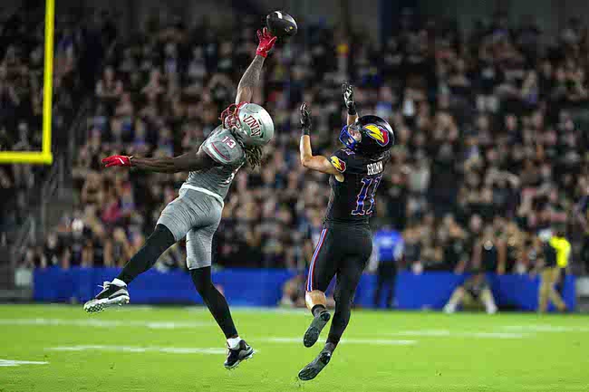 UNLV defensive back Jarvis Ware, left, tips the ball away from Kansas wide receiver Luke Grimm (11) in the second half of an NCAA college football game Friday, Sept. 13, 2024, at Children's Mercy Park in Kansas City, Kan. (AP Photo/Ed Zurga)