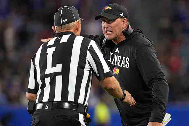 Kansas head coach Lance Leipold, right, talks to an official, left, after a penalty in the second half of an NCAA college football game against UNLV game Friday, Sept. 13, 2024, at Children's Mercy Park in Kansas City, Kan. (AP Photo/Ed Zurga)